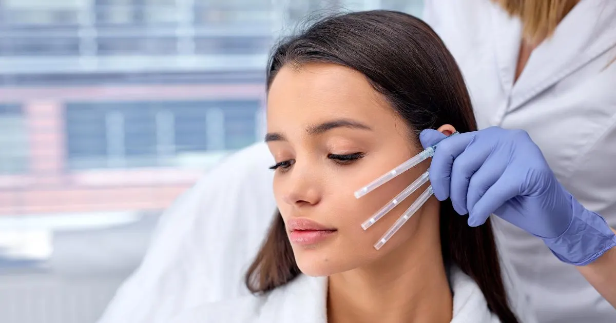Practitioner using a syringe, symbolizing the needle insertion for placing PDO thread lifting threads to redefine the jawline and improve skin firmness.